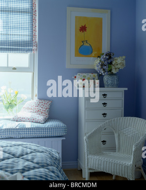 Chaise blanche et la poitrine de tiroirs en pays bleu bleu chambre avec fenêtre vérifié aveugles sur la fenêtre ci-dessus-siège Banque D'Images