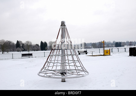 Une aire de jeux pour enfants dans un parc couvert de neige Banque D'Images