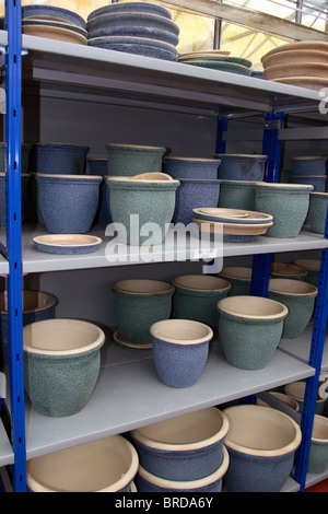 Divers pots de jardin pour les plantes et arbustes empilés sur des étagères au garden centre Banque D'Images