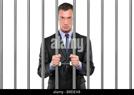 Un homme menotté en prison bars holding Banque D'Images