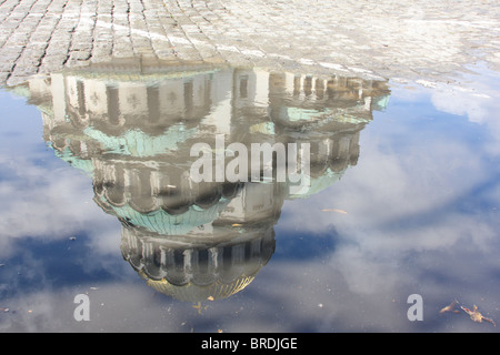 Reflet de la cathédrale Alexandre Nevski dans une piscine de l'eau, les pavés de la rue visible Banque D'Images