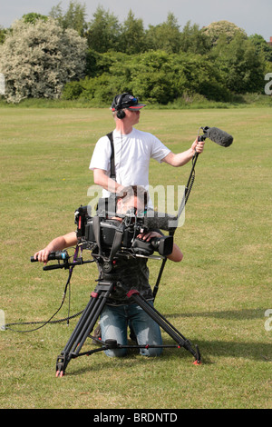 Un film de télévision crew (cameraman et preneur de son) travaillant dans un parc public, Hounslow, Middx, UK Banque D'Images