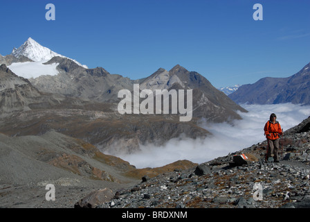 Randonneur sur 'Glacier Trail au-dessus de la vallée de Zermatt avec la matière dans le brouillard et Weisshorn (l), Suisse Banque D'Images