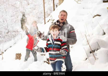 Family Having Snowball Fight In Snowy Landscape