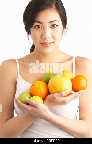 Jeune femme tenant les agrumes en Studio Banque D'Images