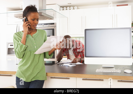 Jeune couple discuter finances personnelles dans une cuisine moderne Banque D'Images