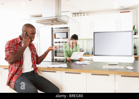 Jeune couple discuter finances personnelles dans une cuisine moderne Banque D'Images