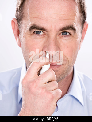 L'homme à l'aide de spray nasal Banque D'Images