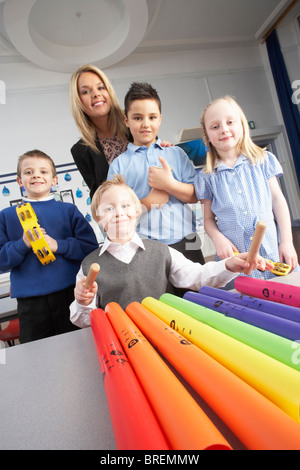 Groupe d'écoliers du primaire et l'enseignant ayant Leçon de Musique en classe Banque D'Images