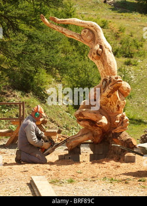 Artiste sculpteur la création d'une sculpture en bois à l'aide d'une tronçonneuse dans Les Orres, Hautes Alpes, France Banque D'Images