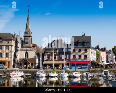 Le port de Honfleur, en France, avec le musée de la ville, avec spire, et yachts amarrés à quai Banque D'Images
