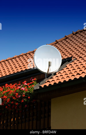 Antenne satellite sur le toit d'une maison neuve. Banque D'Images