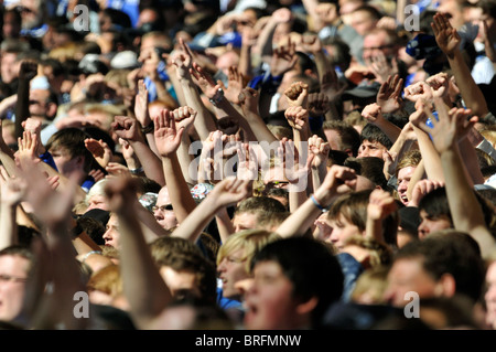 Les spectateurs de football match lever leurs mains en l'air à l'appui de leur équipe Banque D'Images