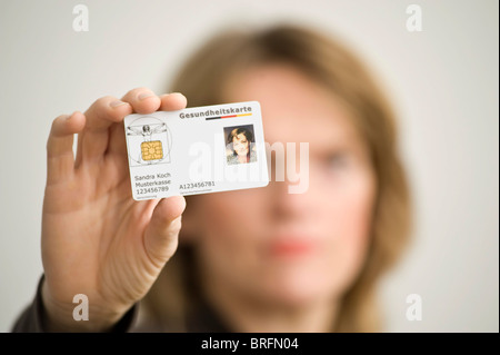 Femme tenant une carte d'assurance maladie électronique allemand Banque D'Images