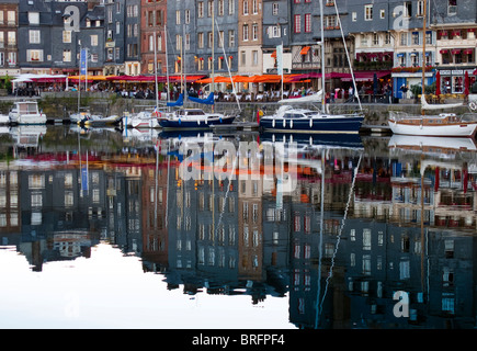 Restaurants le quai et les yachts sont amarrés dans le port de Honfleur en début de soirée sur la côte Atlantique de la France Banque D'Images