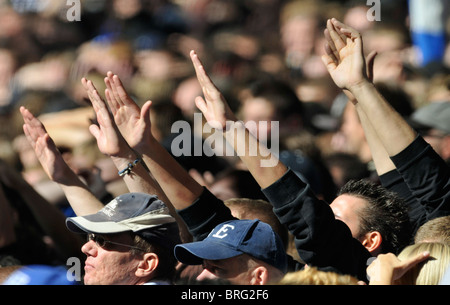 Les spectateurs de football match lever leurs mains en l'air à l'appui de leur équipe Banque D'Images