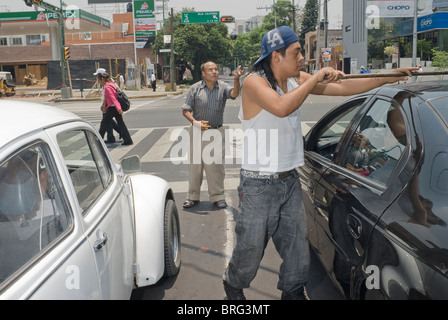 La rue reste le dernier refuge des chômeurs, comme ces nettoyants voiture vadrouille dans la ville de Mexico. Banque D'Images