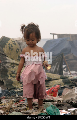 Une jeune fille affiche les effets de la vie dans une décharge à la décharge de Stung Meanchey à Phnom Penh, Cambodge. Banque D'Images