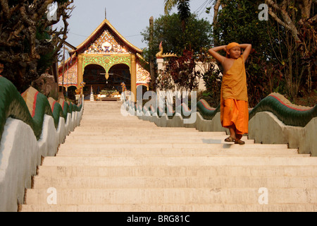 Un moine bouddhiste novice marche dans un long vol d'escaliers dans un temple situé près du fleuve Mékong à Huay Xai, la Thaïlande. Banque D'Images