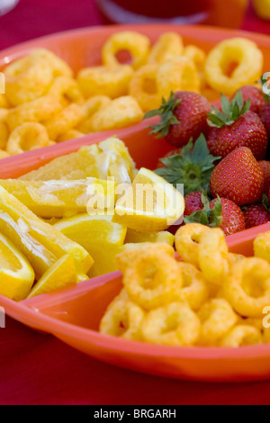 Close-up de fraises, de tranches de citron et fromage boucles dans un bol divisé. Format vertical. Banque D'Images