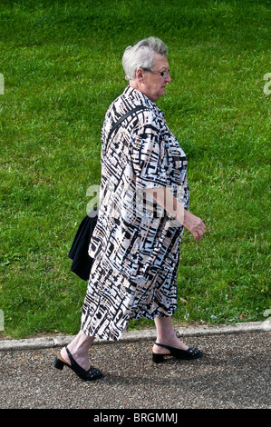 Mature / middle-aged woman walking on pavement - France. Banque D'Images