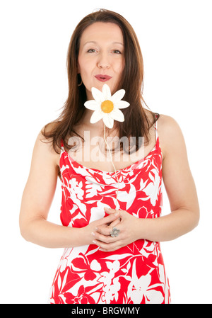 Belle mature woman blowing on artificial daisy isolated on white Banque D'Images