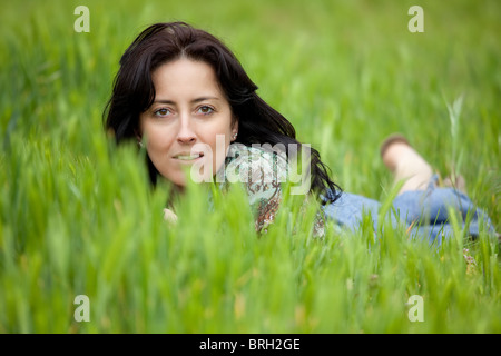 Woman lying on grass looking at camera Banque D'Images