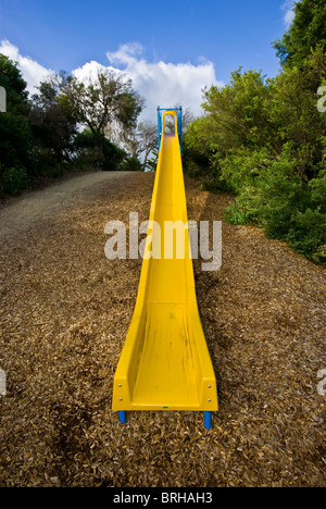 Une longue ligne droite, faites glisser l'enfant jaune vif dans une aire de jeux. Banque D'Images