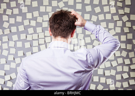 Businessman Looking at un mur plein de notes auto-adhésif Banque D'Images