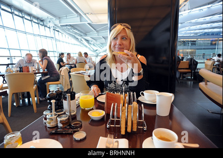 Une femme jouit d'hôtes à Gordon Ramsay's 'Plane Food' restaurant à Heathrow Terminal 5 avant son vol Banque D'Images