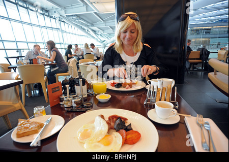 Une femme jouit d'hôtes à Gordon Ramsay's 'Plane Food' restaurant à Heathrow Terminal 5 avant son vol Banque D'Images