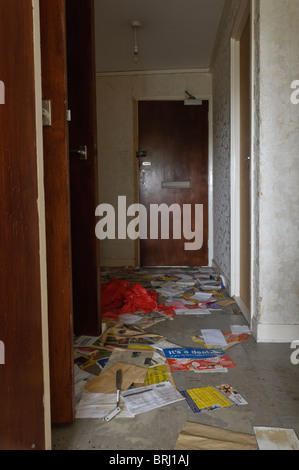 Post non lu éparpillés sur le plancher de la salle d'une télévision abandonnés Banque D'Images