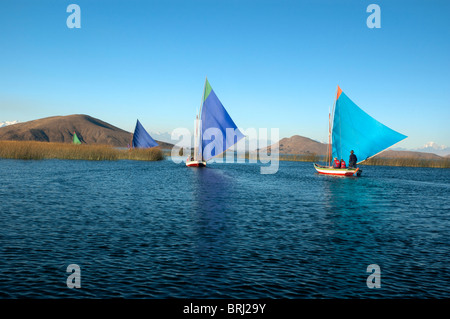Les touristes dans de petits bateaux à voile à l'île d'Anapia, le Lac Titicaca, au Pérou. Banque D'Images