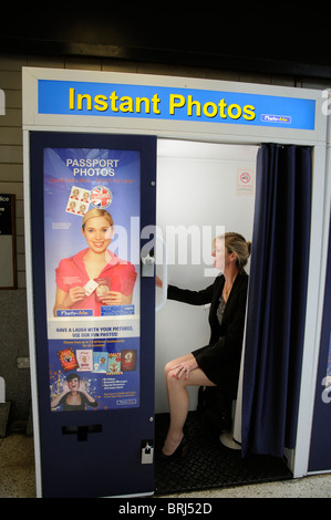 Photo Booth femme préparant d'avoir pris en photo à l'aide de passeports machine portrait public Banque D'Images