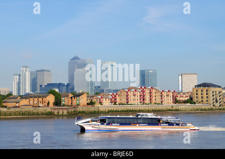 Un riverbus Thames Clippers passant Canary Wharf et Riverside Apartments sur l'Isle of Dogs, Docklands, London, England, UK Banque D'Images