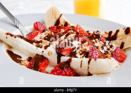 Une assiette santé de banana split avec du yogourt faible en gras, les fraises et sucre ajouté Banque D'Images