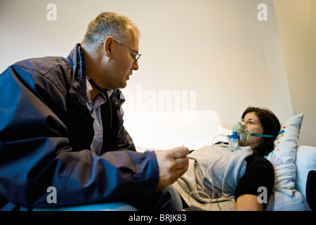 Médecin d'urgence sur appel l'administration d'oxygène au patient en accueil Banque D'Images