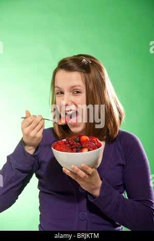 Teenage Girl Eating Bowl de baies Banque D'Images