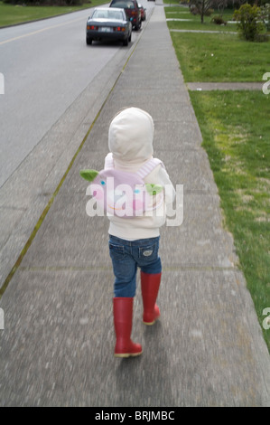 Petite fille d'exécution sur le trottoir Banque D'Images