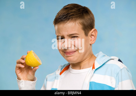 Boy Eating a Lemon Banque D'Images