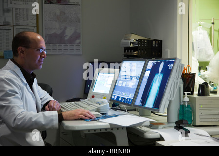 Médecin homme l'évaluation examen médical résultat sur le moniteur de l'ordinateur Banque D'Images
