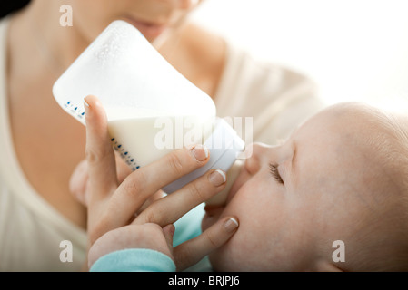 Boire du lait pour bébé à partir de la bouteille Banque D'Images