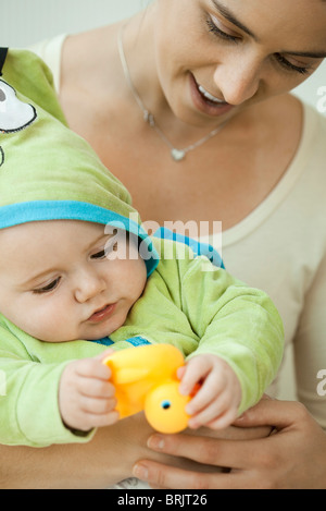 Mère et l'enfant jouant avec le canard en caoutchouc avant le bain Banque D'Images