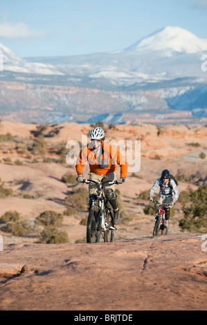 Deux jeunes hommes montent leurs vtt sur le sentier Slickrock, Moab, UT. Banque D'Images