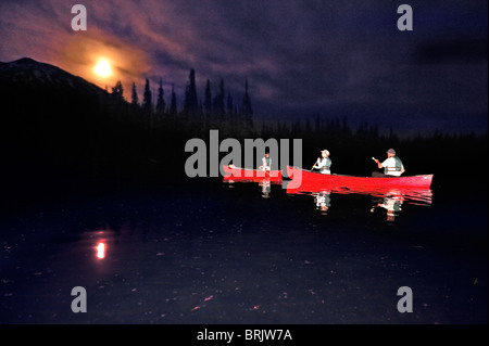 Un groupe canoë dans un bateaux rouges dans la nuit sur un lac de montagne dans l'Oregon. Banque D'Images