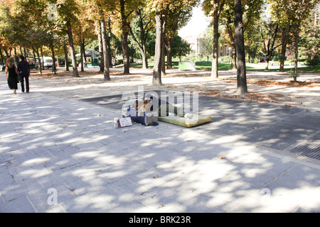 Homme avec chien mendier à Paris sur un trottoir des Champs-Elysées Banque D'Images