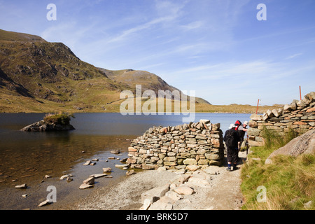 Le CWM Idwal, Ogwen, au nord du Pays de Galles, Royaume-Uni. Les marcheurs en passant par la porte en mur de pierre sur le chemin par Llyn Idwal Lake dans la région de montagnes de Snowdonia Banque D'Images