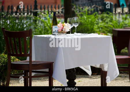 Verres à vin et bouteille de vin à table avec nappe blanche à l'extérieur Banque D'Images