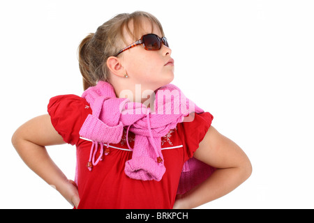 Fière petite fille portant des lunettes de soleil à la recherche jusqu'à quelque chose d'isolé sur fond blanc Banque D'Images