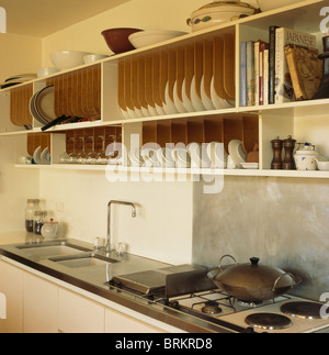 Plaque en bois équipé de racks étalage au-dessus de l'évier et cuisinière à gaz dans la cuisine moderne Banque D'Images